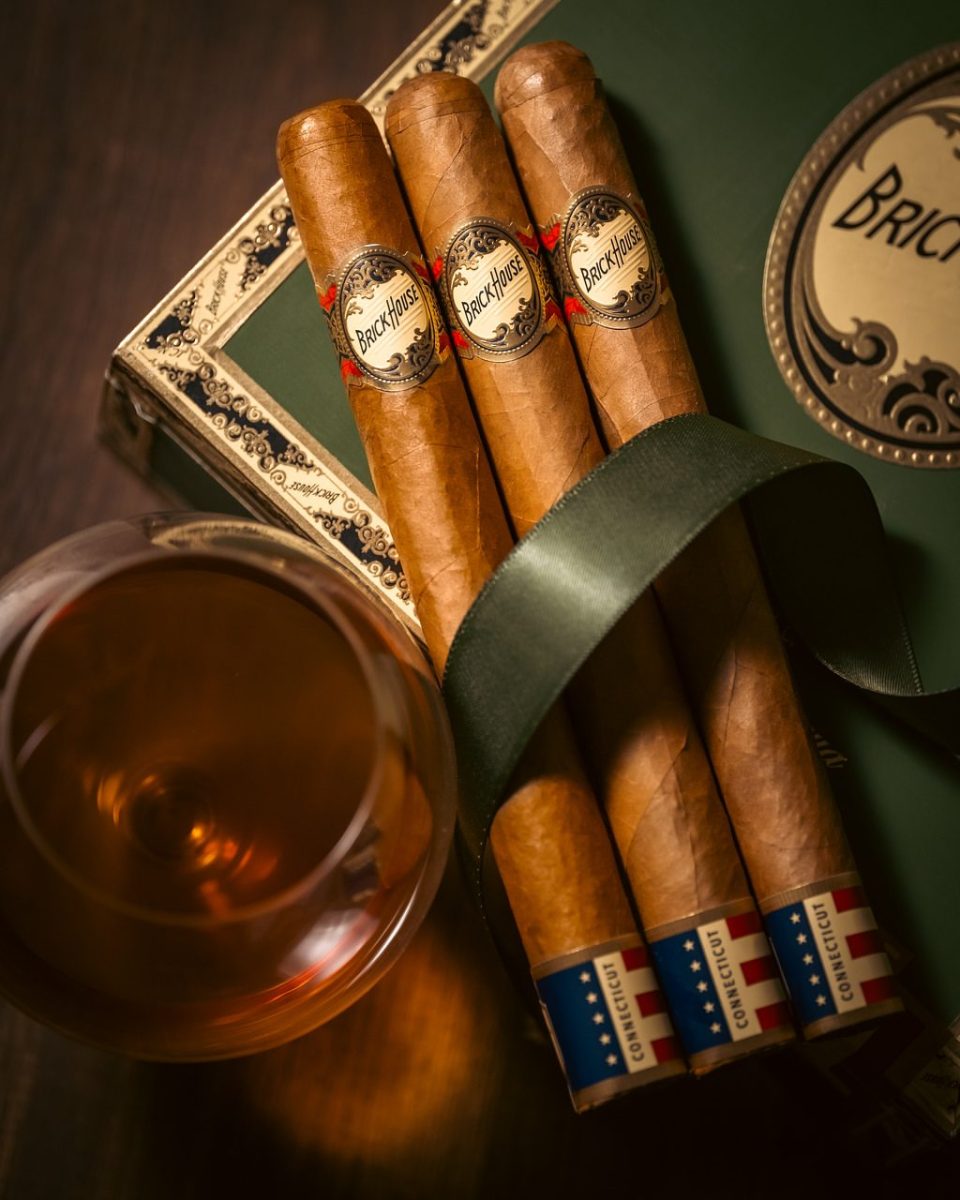 Brick House cigars with a glass of whiskey on a green gift box